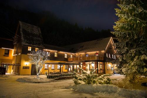 a large building in the snow at night at Flair-Waldhotel Mellestollen in Saalfeld