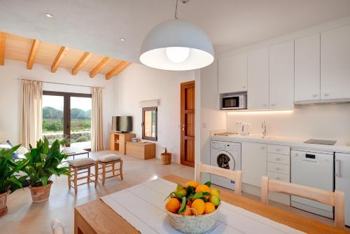 a kitchen and living room with a bowl of fruit on a table at son capellot in Felanitx