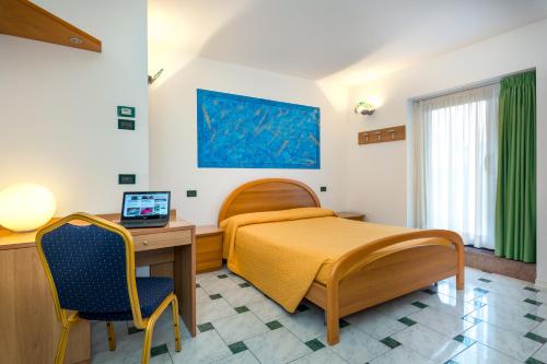 ein Krankenhauszimmer mit einem Bett, einem Schreibtisch und einem Computer in der Unterkunft Hotel Centrale in Latisana