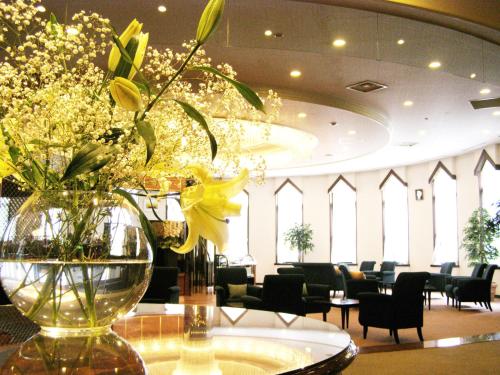 a vase of flowers on a table with chairs at Hotel Marroad Karuizawa in Karuizawa