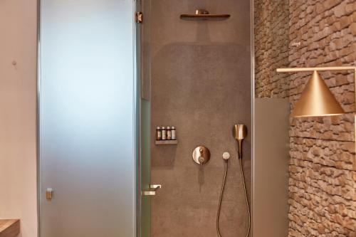 a shower with a shower head in a bathroom at Myconian Naia - Preferred Hotels & Resorts in Mýkonos City