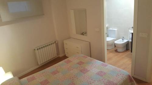 a small bathroom with a bed and a toilet at Apto. En Mundaka in Mundaka