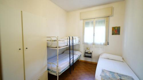 a small room with two bunk beds and a window at Villetta Logonovo in Lido di Spina