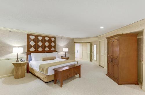 a bedroom with a large bed and a wooden cabinet at Caesars Atlantic City Hotel & Casino in Atlantic City