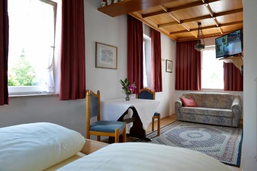 ein Schlafzimmer mit einem Bett, einem Tisch und einem Sofa in der Unterkunft Hotel Bezold in Rothenburg ob der Tauber