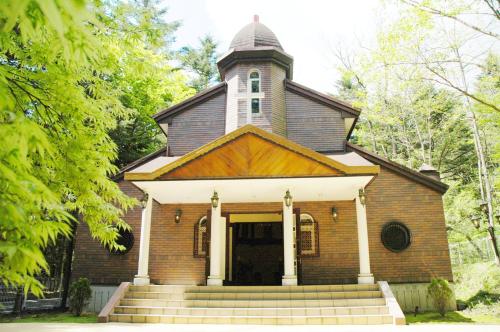 an old brick building with a tower on top at Hotel Marroad Karuizawa in Karuizawa
