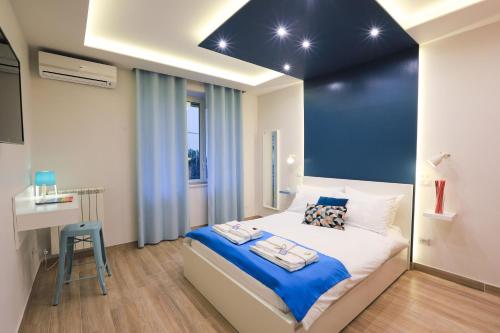 1 dormitorio con cama y pared azul en Vacuna Pleasant Rooms en Nápoles