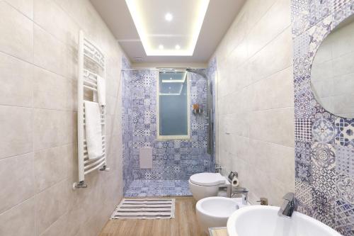 ein Badezimmer mit einem WC, einem Waschbecken und einem Spiegel in der Unterkunft Vacuna Pleasant Rooms in Neapel