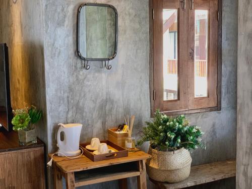 a room with a table with a mirror and a window at Sand in My Shoes Beach Loft in Thong Nai Pan Noi