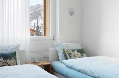 a bedroom with two beds and a window at Haus-Ascot-Zermatt in Zermatt