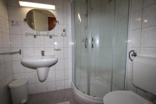 a bathroom with a sink and a shower and a toilet at Hotel Móló in Siófok
