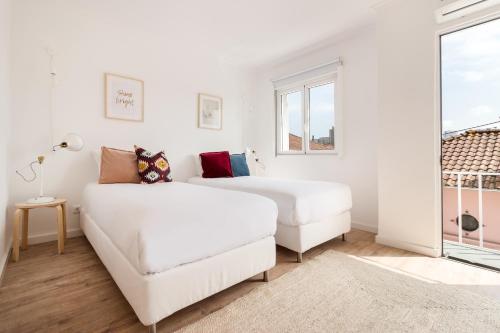 una camera da letto bianca con due letti e un divano di Gaia Retreat • 2 BD · A/C a Vila Nova de Gaia