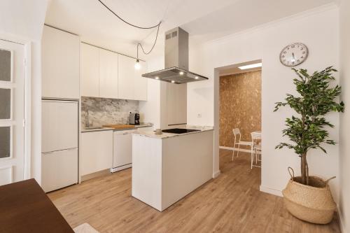 a kitchen with white cabinets and a clock on the wall at Gaia Retreat • 2 BD · A/C in Vila Nova de Gaia