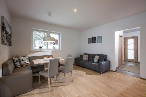 a living room with a table and a couch at Landhaus Desiree in Hopfgarten im Brixental