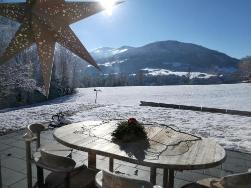 a table with a flower arrangement on it in the snow at Landhaus Desiree in Hopfgarten im Brixental