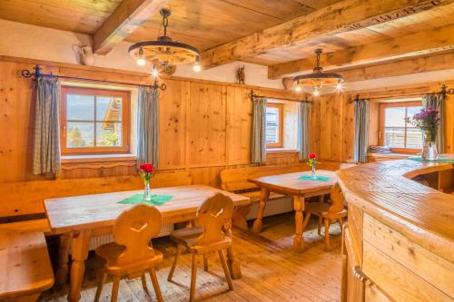 a dining room with wooden walls and wooden tables and chairs at Kohlschnait-Hütte in Bruck an der Großglocknerstraße