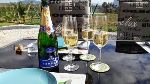 een tafel met wijnglazen en een fles champagne bij Villa Finiki Messinia upstairs in Foiníki