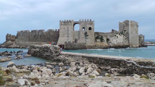an old castle in the water next to some rocks at Villa Finiki Messinia upstairs in Foiníki