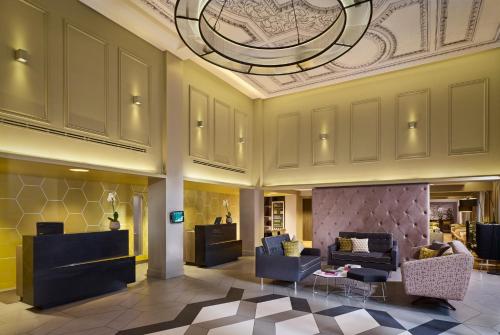 a lobby with couches and chairs and a ceiling at Citadines Trafalgar Square in London