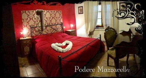 a bedroom with a red bed with a white heart shaped pillow at Podere Mazzarelle in Castel del Piano