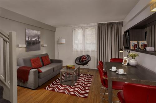 a living room with a couch and a table at Citadines Trafalgar Square London in London