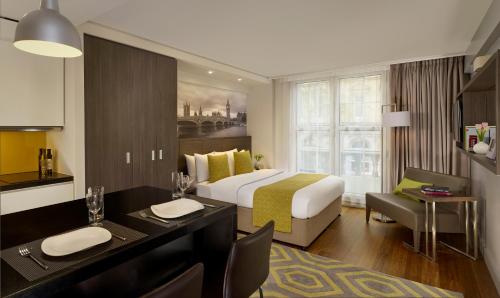 a hotel room with two beds and a table at Citadines Trafalgar Square in London