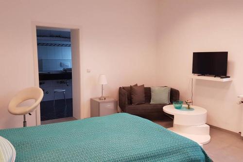 1 dormitorio con cama, sofá y TV de pantalla plana en Zimmervermietung Mülheim, en Mülheim an der Ruhr