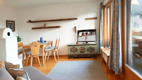 uma sala de estar com uma televisão e uma mesa de jantar em Schmiedhof em Seefeld in Tirol