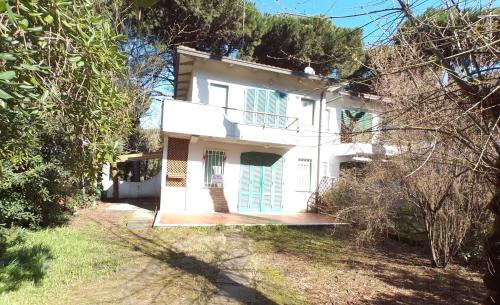 a white house in the middle of a yard at Villetta Logonovo in Lido di Spina