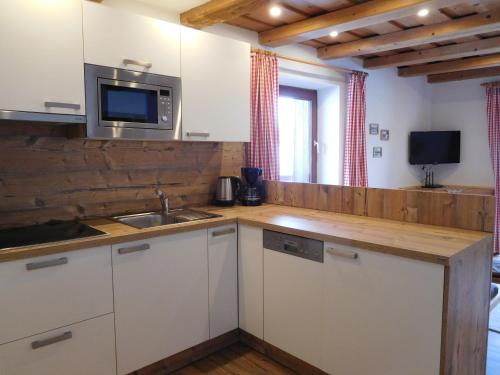 a kitchen with a sink and a microwave at Thoamlhof in Leutasch