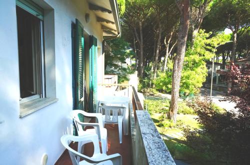a porch with chairs and a table and a window at Villetta Logonovo in Lido di Spina