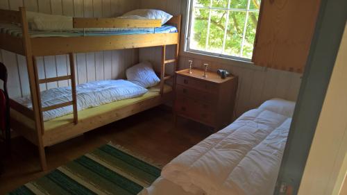a bedroom with two bunk beds and a window at Eikheim in Birkeland
