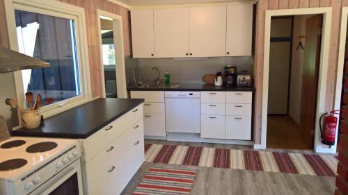 a kitchen with white cabinets and a black counter top at Eikheim in Birkeland