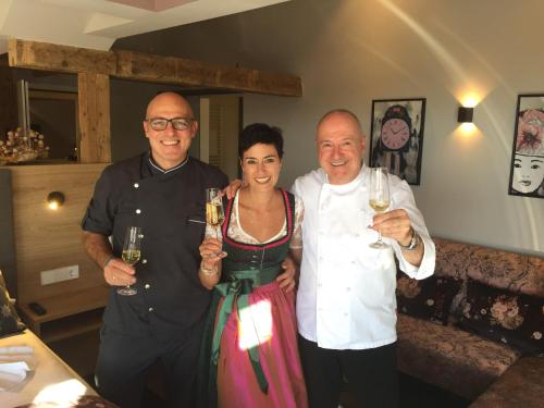 two men and a woman holding glasses of wine at Hotel Restaurant Der Engel, Sasbachwalden in Sasbachwalden
