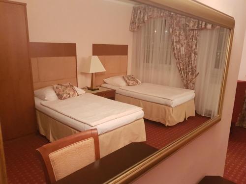 a reflection of a hotel room with two beds in a mirror at Eurohotel in Karlovy Vary