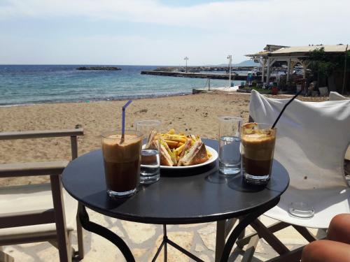 a table with a plate of food and drinks on the beach at Villa Finiki Messinia upstairs in Foiníki