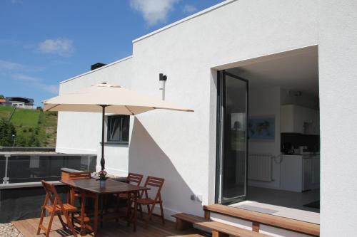 un patio con mesa y sombrilla en Plena naturaleza en Pleno San Sebastián, en San Sebastián