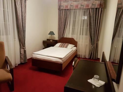 a hotel room with a bed and a table at Eurohotel in Karlovy Vary