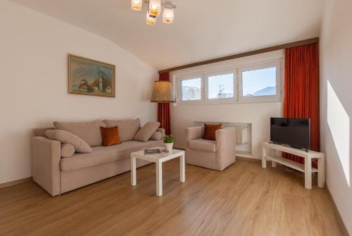a living room with a couch and a tv at Haus Kuen in Merano