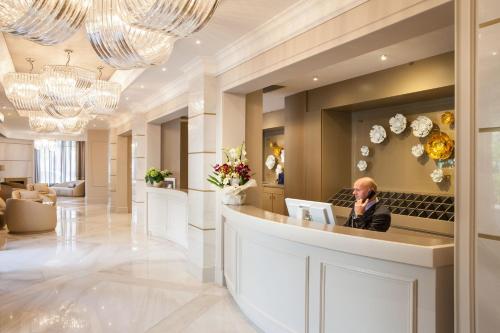 a man sitting at a bar in a hotel lobby at Hotel Dei Fiori Restaurant - Meeting & Spa in Alassio