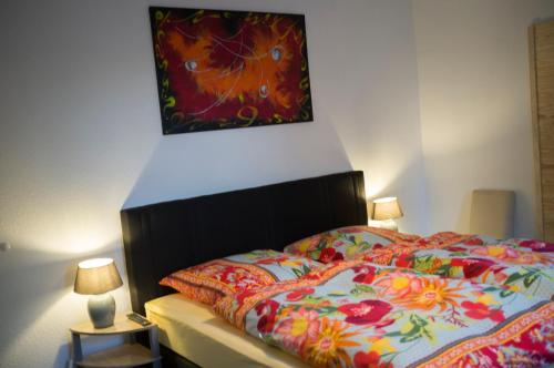 ein Schlafzimmer mit einem Bett mit einem Gemälde darüber in der Unterkunft Quadenhof in Düsseldorf
