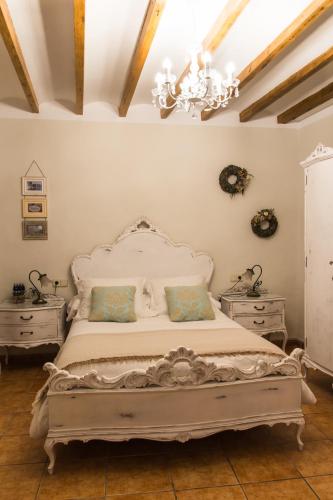 a bedroom with a bed with two dressers and a chandelier at Casa Rosalía in Ibi