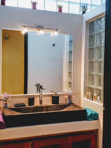 a bathroom with a sink and a large mirror at La Maison Blanche à Ngaparou, splendide villa contemporaine in Ngaparou