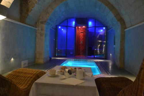 a bathroom with a tub with a table and chairs at Palazzo Muro Leccese Relais de Charme & Wellness in Muro Leccese