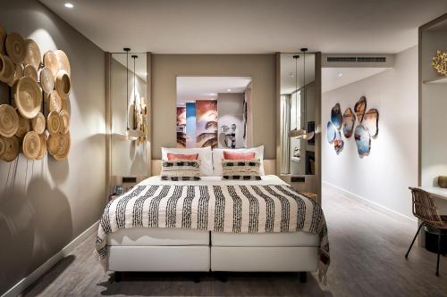 a bedroom with a bed and some pictures on the wall at Van der Valk Hotel Tilburg in Tilburg