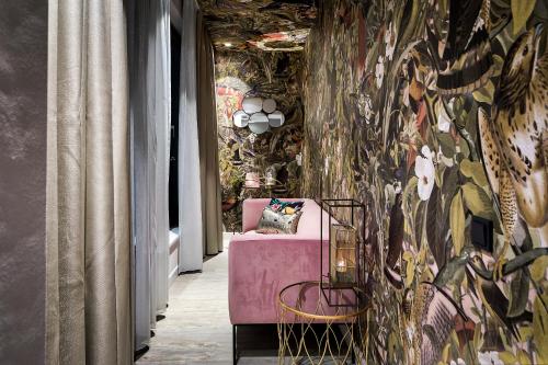 a room with a pink chair and a colorful wall at Van der Valk Hotel Tilburg in Tilburg