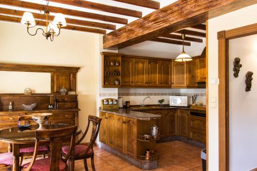 a kitchen with wooden cabinets and a table at Casa Rosalía in Ibi