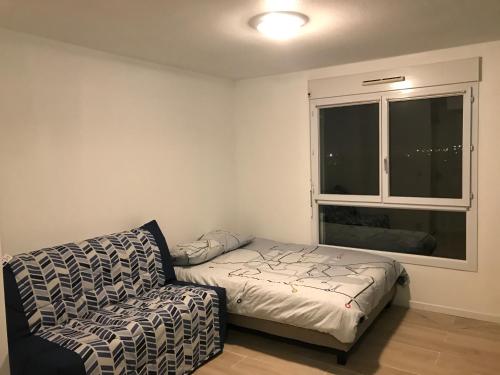 a living room with a couch and a window at Appartement Futuroscope-J' in Jaunay-Marigny