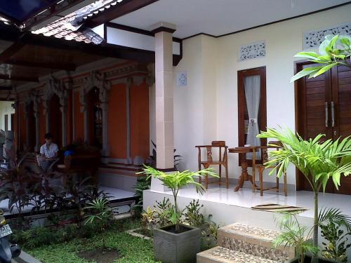 a man sitting on the porch of a house at Kirana Home Stay in Sanur