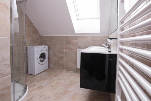 a bathroom with a washing machine and a sink at Chalupa Kadov in Sněžné